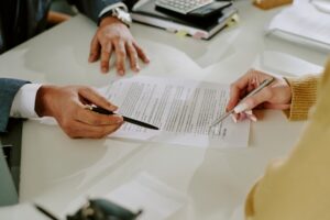 An attorney and a client review legal documents during a meeting about a wrongful death settlement and related financial issues in New York. Most wrongful death settlements are generally not taxable under federal or New York law.